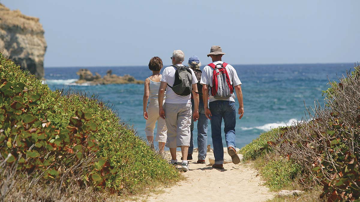 adults hiking on the beach