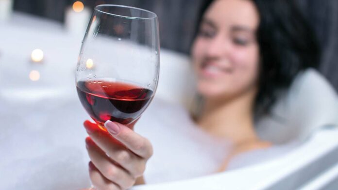 Jacuzzi Family Vineyards’ Merlot 2012 drinking wine in the jacuzzi