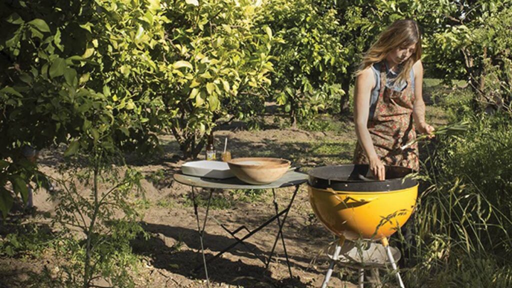 Laura Freed of Wilder Condiments grilling in an orchard