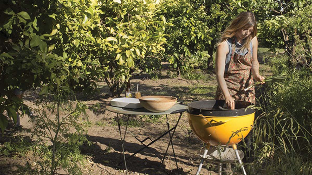 Laura Freed of Wilder Condiments grilling in an orchard