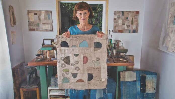 Turning Discarded Books into Art Artist Jody Alexander with her work