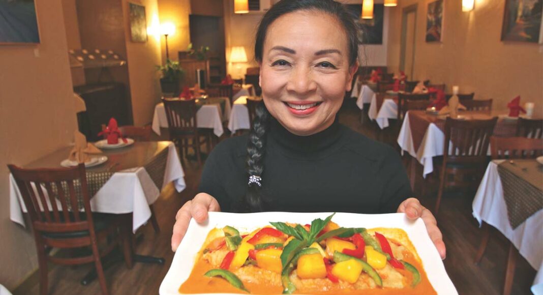 Ratana Bowden of Real Thai Kitchen holds a red curry with fish and mango.