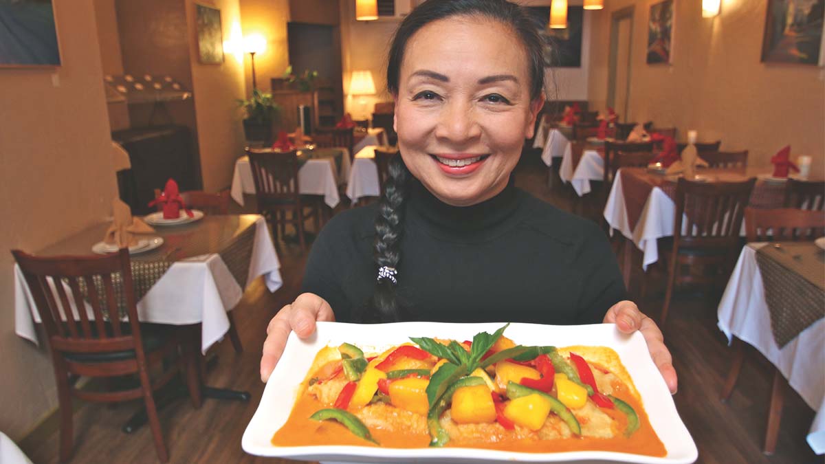 Ratana Bowden of Real Thai Kitchen holds a red curry with fish and mango.