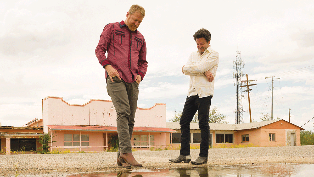 Members of the band Cracker in front of abandoned store front