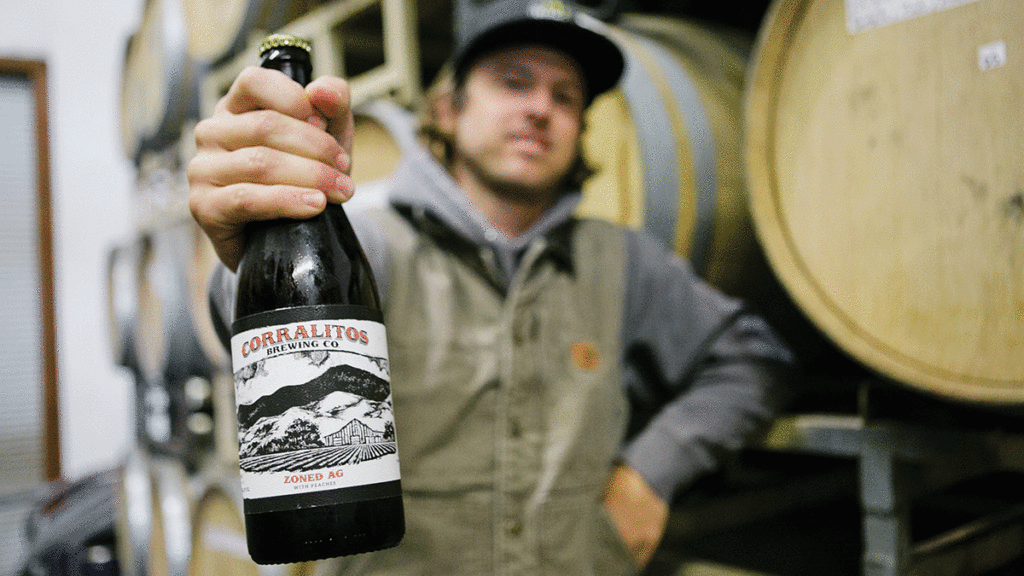 Corralitos Brewing owner Luke Taylor with bottle of Zone Ag Peach