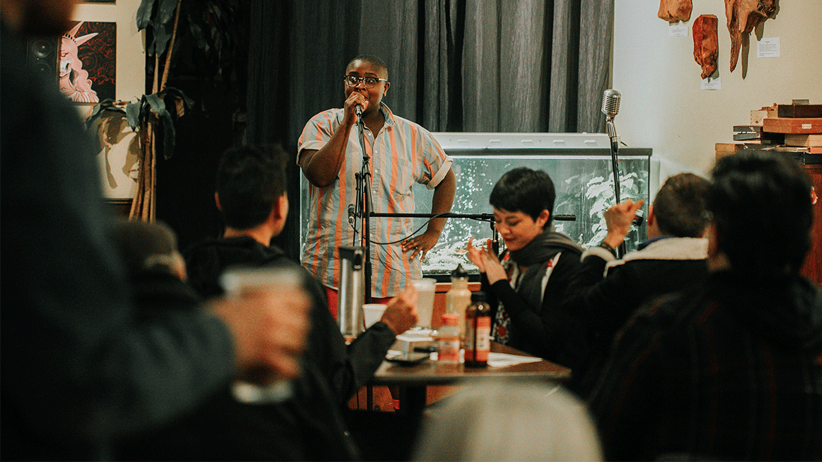 Ezra Bowen, the new transgender program coordinator for the Diversity Center, addresses the crowd at a recent open mic. PHOTO: KEANA PARKER