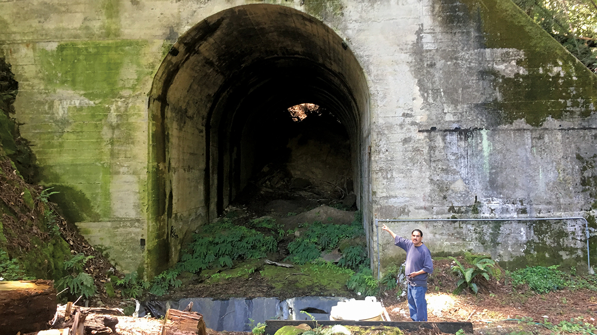 Jose Bernebe stands in front of the Glenwood Tunnel historic train to san jose from santa cruz