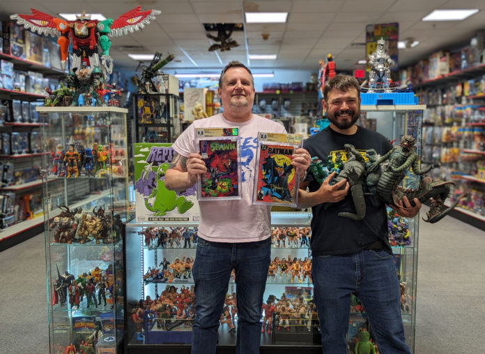 Talk Nerdy to Me: Surf City Comic Con Debuts April 20 Two men holding up comics at toys in a collectibles shop