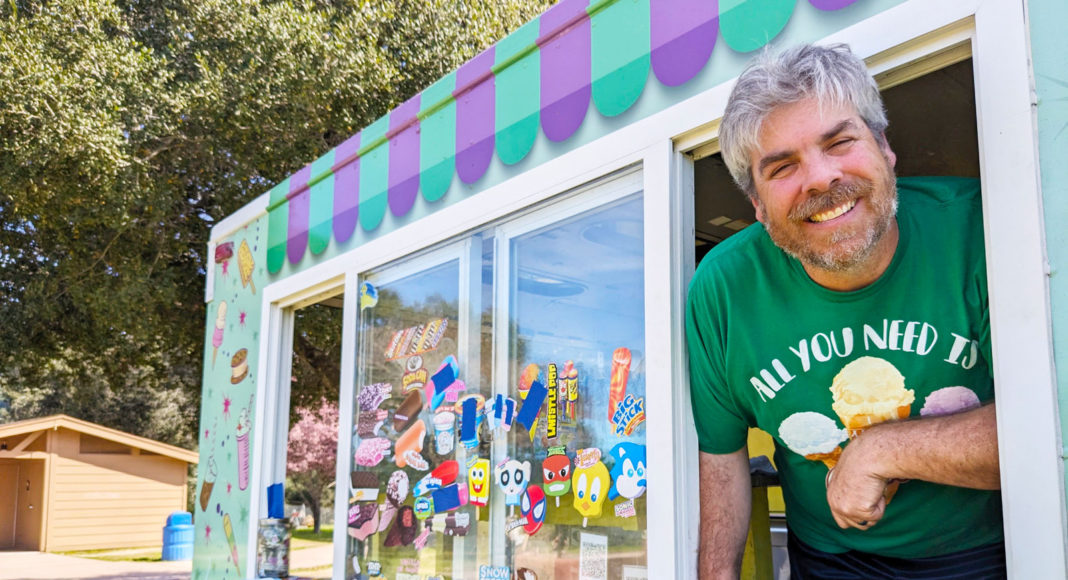 Smiling man leaning out of a food truck