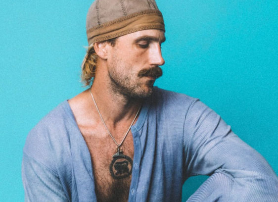 Rayland Baxter Flys into Rio Theatre for May 14 Concert Portrait of a man on a bright blue background