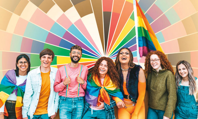 Santa Cruz Pride’s 49th Weekend! Group of happy people before a colorful geometric background.