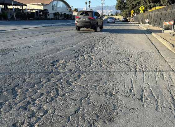 Santa Cruz County Grand Jury Raises Concerns on Deferred Road Repairs car driving down a road with lots of cracks and potholes