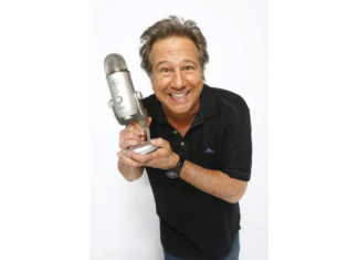 Rock Musician Greg Kihn dies at 75 Man holding up a microphone as if it were an award