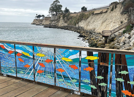 Capitola Wharf’s Next Chapter Photo taken from Capitola Wharf showing new artwork on the wharf and the cliffs along the shore