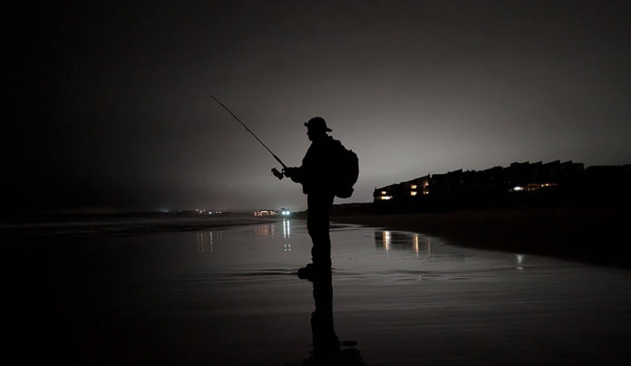 Catching Up Silhouette of a fisherman on a lonely beach at night