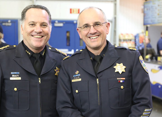 Scotts Valley Contender Steve Clark Has Battled Activists for Decades Two men in police uniforms smiling at the camera