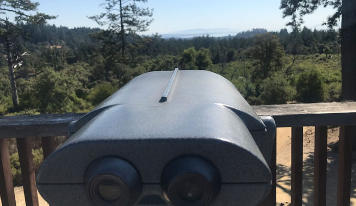 Henry Cowell Observation Deck Loop Trail binoculars on an observation deck overlooking a forest view with the ocean in the distant background