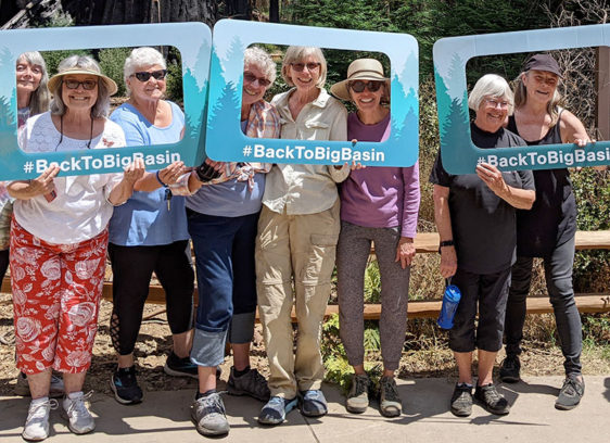 Village Santa Cruz County Builds Generational Bridges Group of people holding up signs that frame their faces and say "BackToBigBasin"