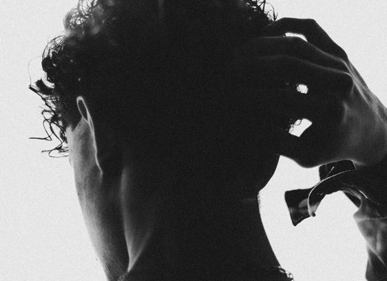 Making the Cut Man photographed from behind in silhouette, putting his hand on his head