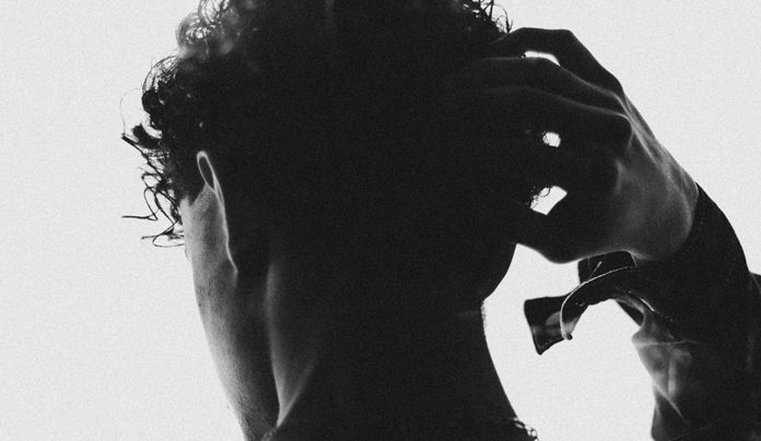 Making the Cut Man photographed from behind in silhouette, putting his hand on his head