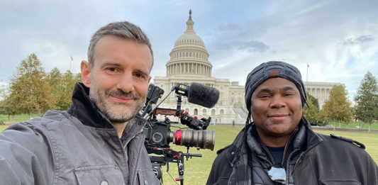 Two men standing in front of the Capitol building