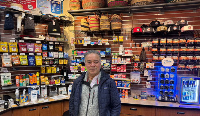 Best of Santa Cruz County 2025: Editorโs Picks Man at a counter with a bunch of retail items behind him