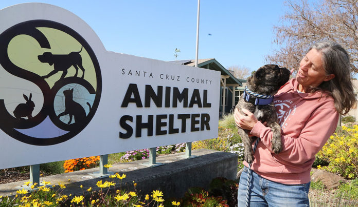 Best of Santa Cruz County 2025: Family & Pets Woman by a sign holding a dog