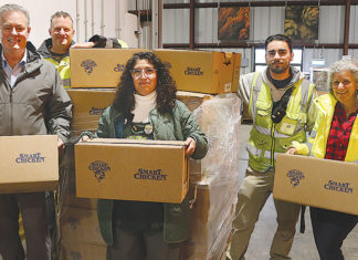 Second Harvest Grapples with Federal Funding Cuts People holding boxes in a warehouse
