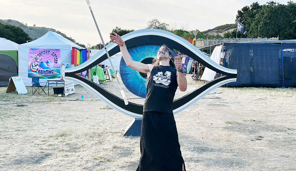 Person in front of a sculpture shaped like the outline of an eye