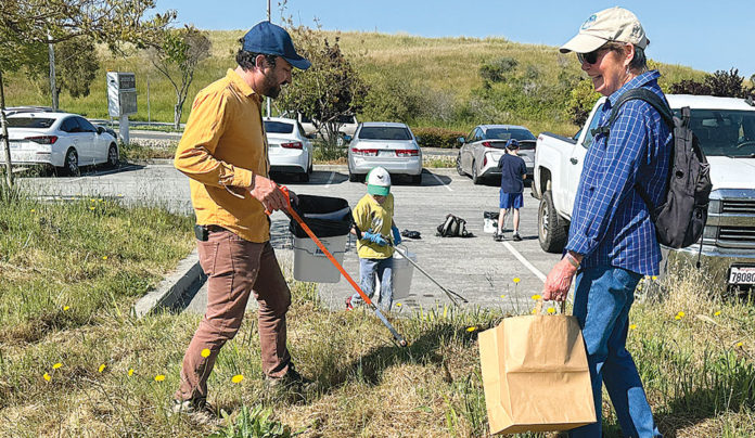 Cleanup Day Draws Hundreds Two people picking up trash