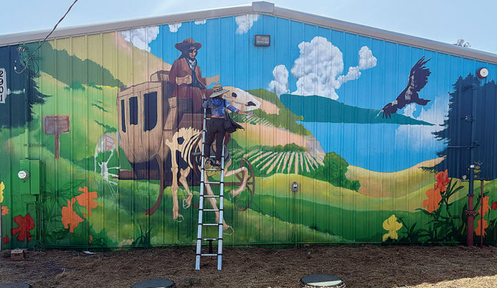 New Mural Depicts Stagecoach Driver Charley Parkhurst Woman painting a mural