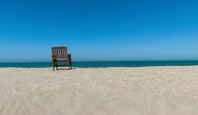 Loneliness Paradox Wellness image solitary beach chair