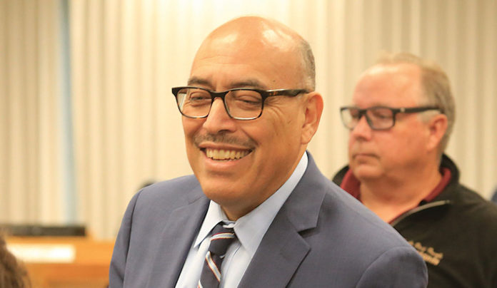 Palacios Steps Down Man in a suit standing in front of another man in a room
