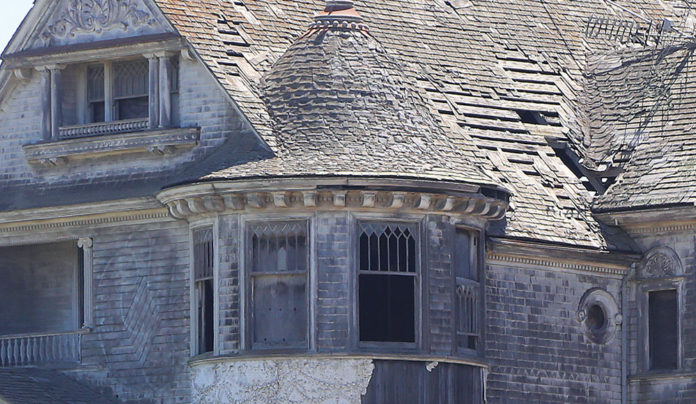 End of an Era Closeup of the upper story of a dilapidated Victorian home