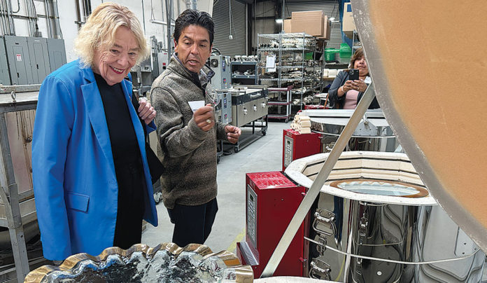 Annieglass Celebrates One Year Since Solar Installation Two people touring a glassmaking factory