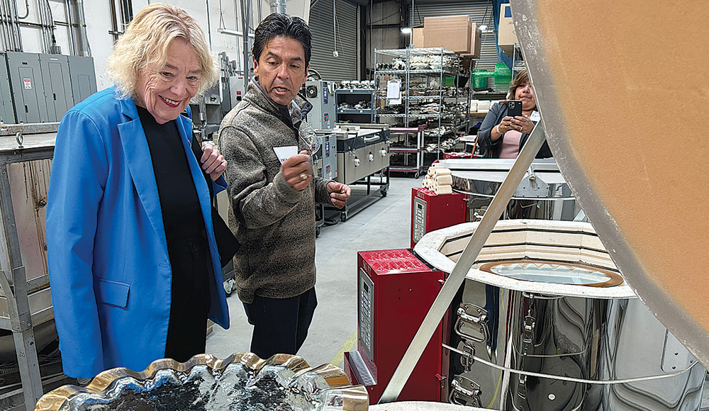 Two people touring a glassmaking factory