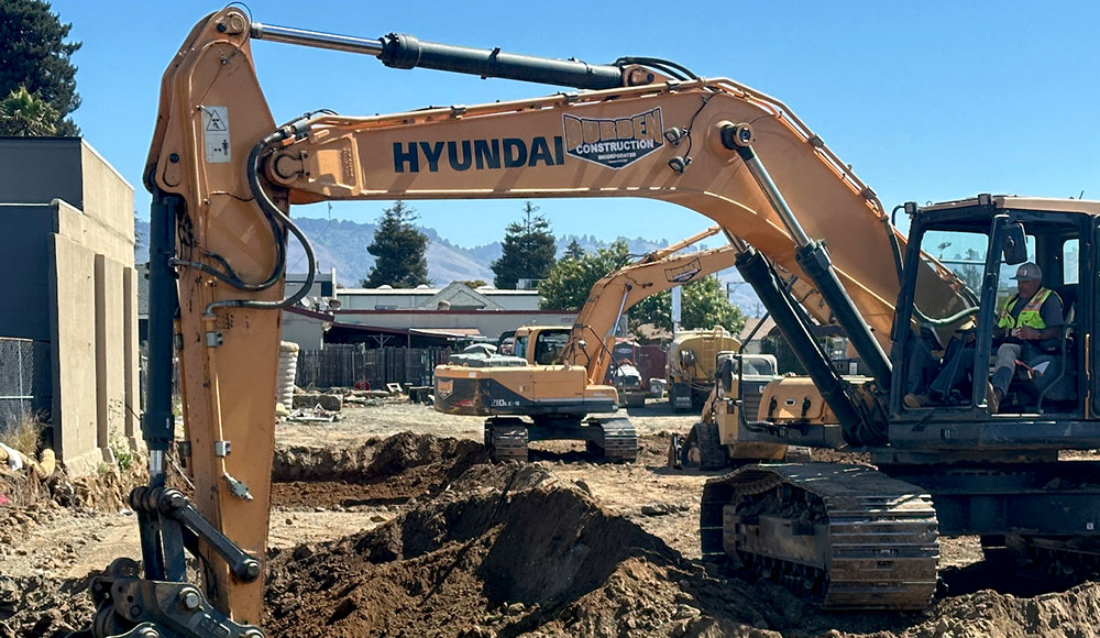 Large equipment moving dirt on a vacant lot