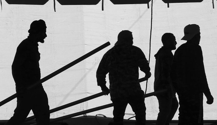County Fair Rolls In Silhouetted figures behind the wall of a tent