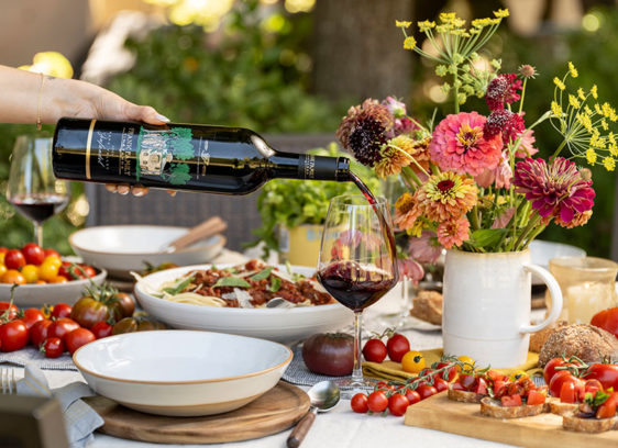 Zin and Virtue a waiter pours red wine into a glass