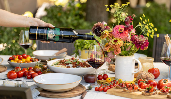 Zin and Virtue a waiter pours red wine into a glass