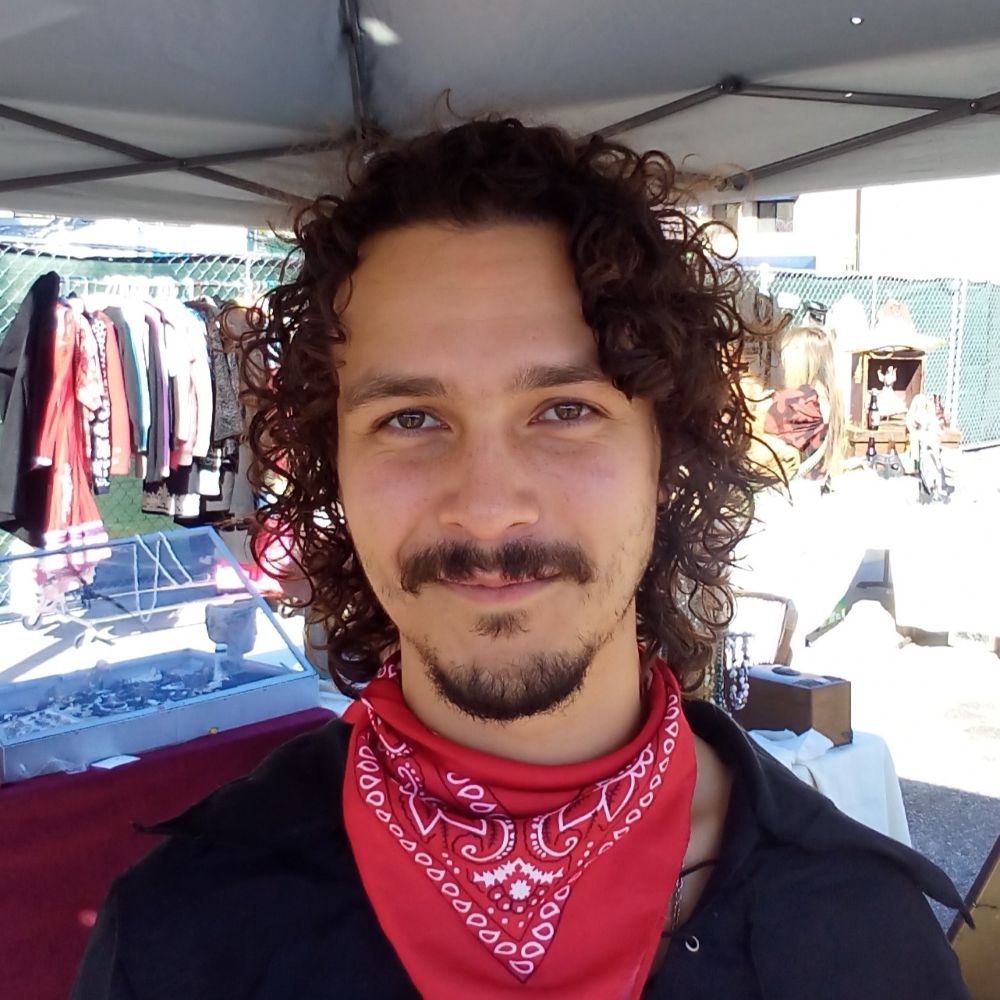 21 year old Kaia with beard, moustache and curly dark hair and red kerchief, interviewed.