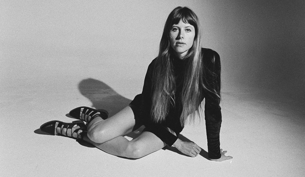 black and white studio shot of Lael Neale sitting on a bare floor