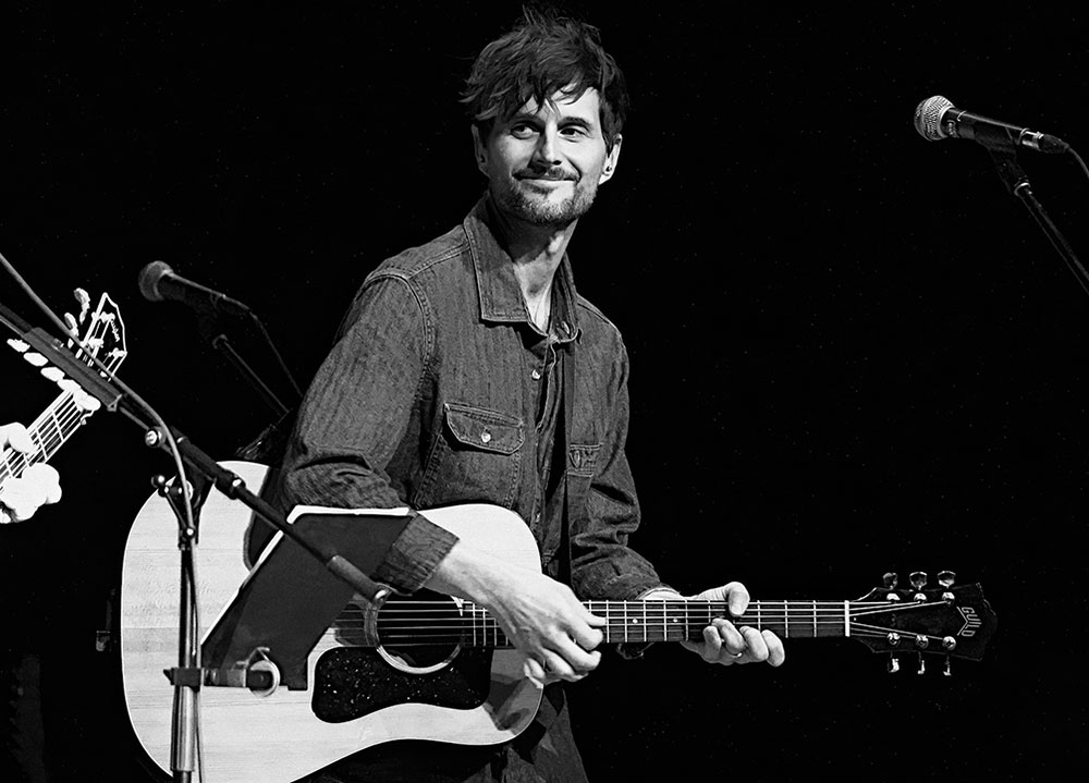 Black and white photo of Andy Barr with guitar