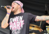 The Editor’s Desk Singer James Durbin singing onstage in an Owen Hart t-shirt and backwards cap.