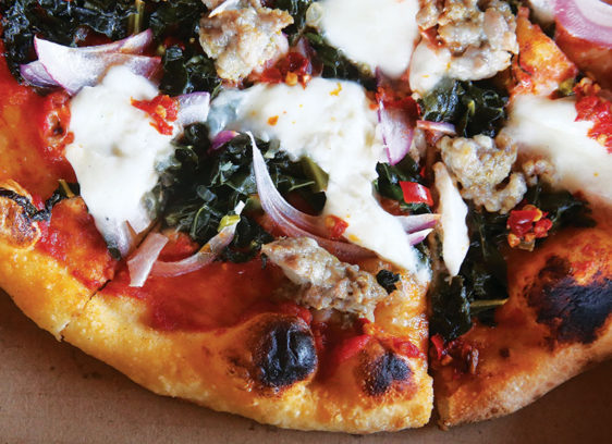 Amore Foray La Posta’s salsiccia pizza, adorned with tomato, kale, burrata and house-made sausage.