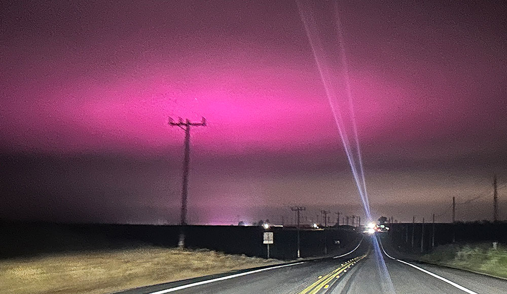 The night sky glows purple recently above the Pajaro Valley as electric lights from a greenhouse on Hilltop Road change to hue of the fog-laced sky.