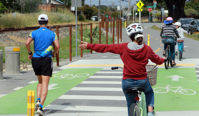 RTC Releases Final Rail-Trail Report A bicyclist and a jogger on what might become the Rail Trail