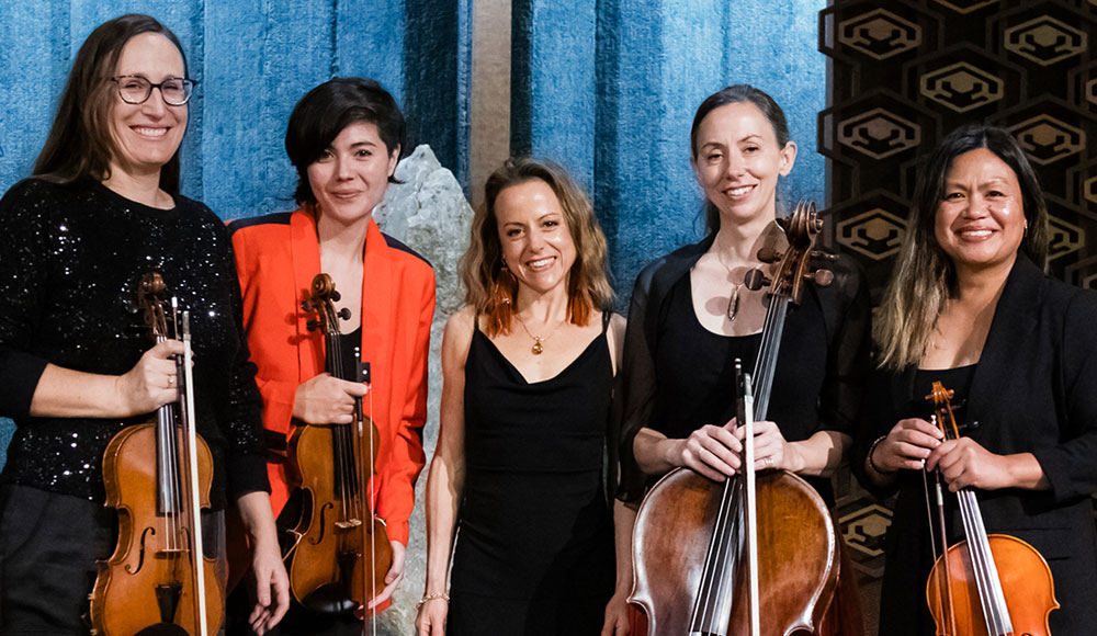 Marea Ensemble members Shannon D’Antonio, Samantha Bounkeua, Lori Schulman, Kristin Garbeff and Rebecca Dulatre-Corbin pose with their string instruments wearing stylish concert dress.