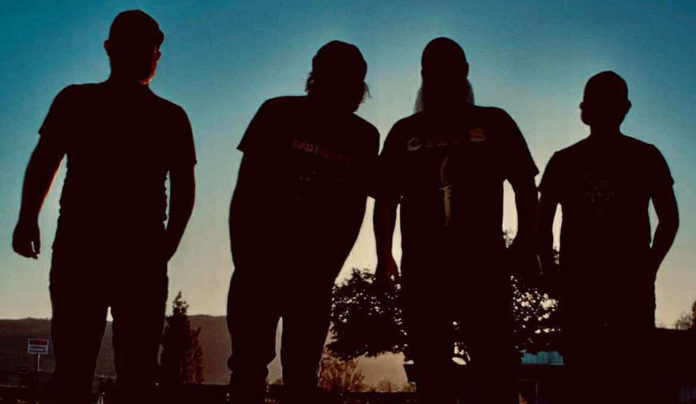 Things to do in Santa Cruz Silhouetted photo of the four members of the rock band Drawing Heaven standing against a dusky blue sky.