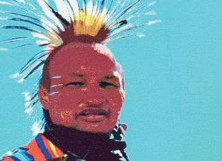 From the Spirit Giclée print of a Native American dancer wearing a colorful traditional outfit and feathered headdress against a bright blue sky.